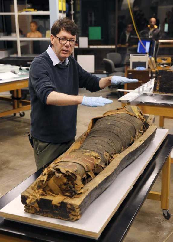 In this photo taken Friday, Dec. 5, 2014, in Chicago, P.J. Brown, Regenstein Conservator at the Field Museum describes the conservation process that will be given to the coffin and mummified body of Minirdis, a 14-year-old Egyptian boy who was the son of a priest.