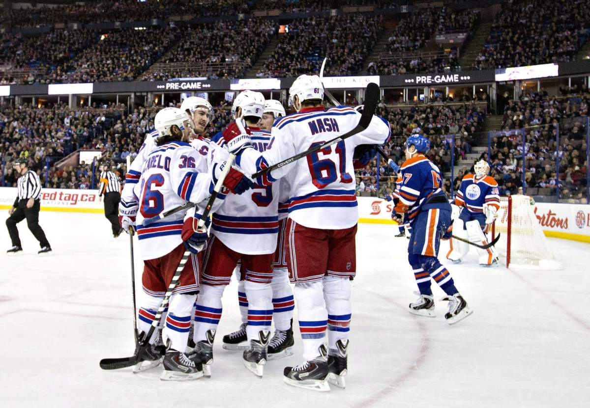 New York Rangers celebrate a goal as Edmonton Oilers’ David Perron (57) and goalie Ben Scrivens (30) look on during first period NHL hockey action in Edmonton, Alta., on Sunday December 14, 2014.
