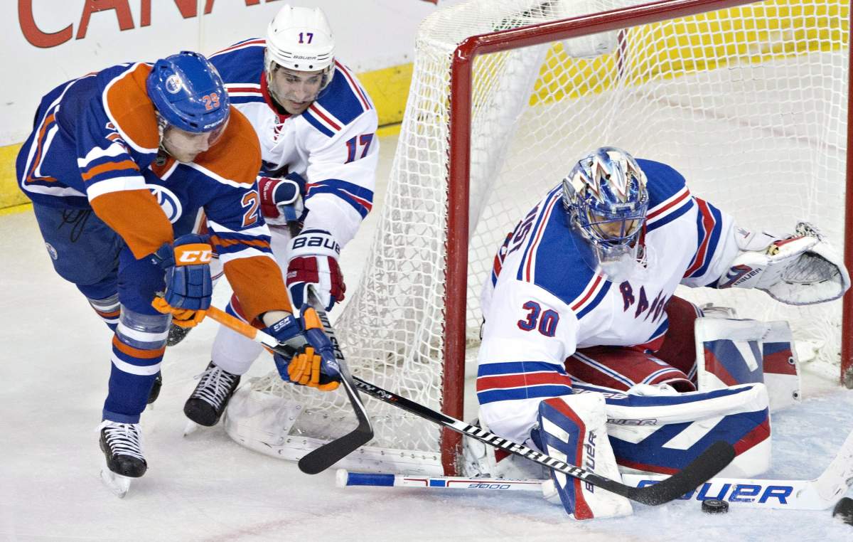 New York Rangers goalie Henrik Lundqvist (30) makes the save on Edmonton Oilers’ Leon Draisaitl (29) as John Moore (17) defends during third period NHL hockey action in Edmonton, Alta., on Sunday December 14, 2014.