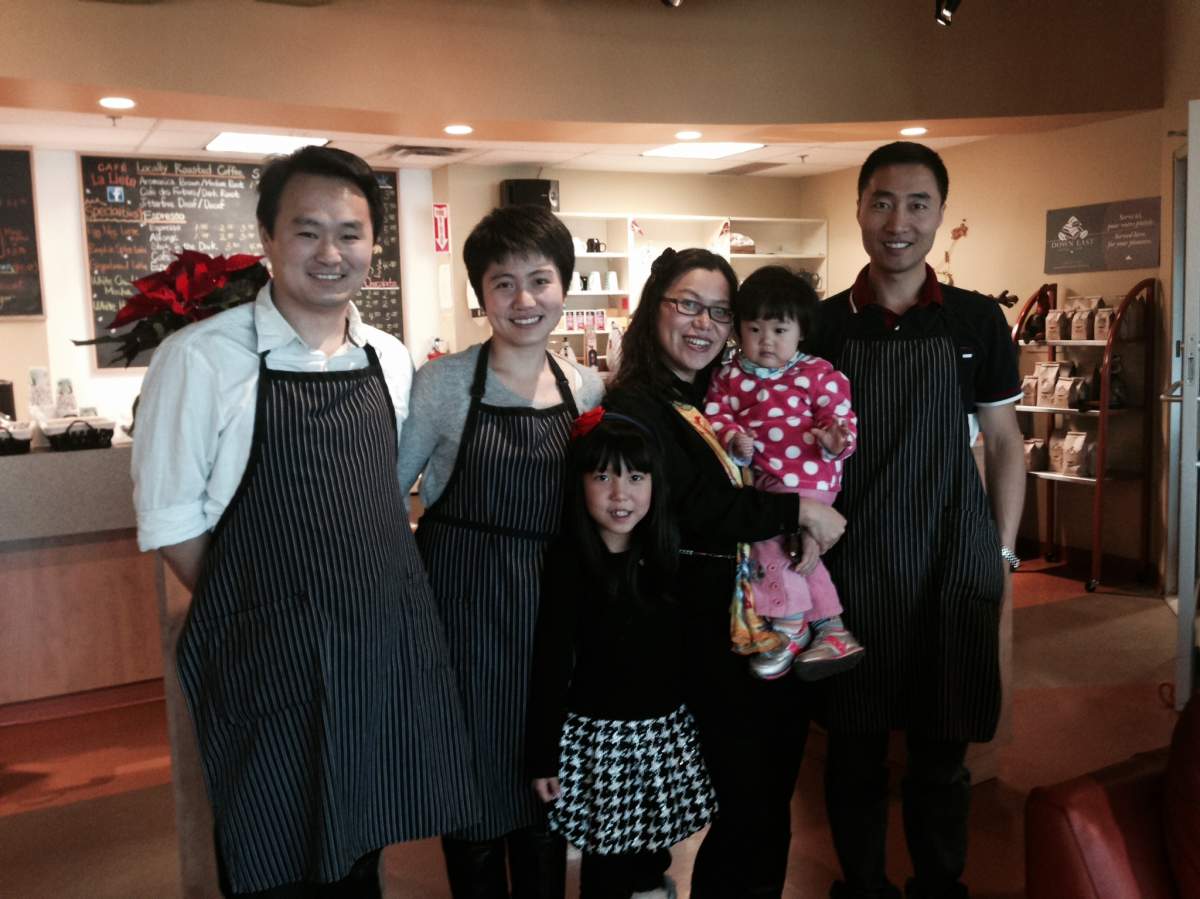 The Wus and Fengs pose for a photo in their new coffee shop in Dieppe, NB. The families are preparing for their first Christmas in their new adopted country. They moved from southern China earlier this year.