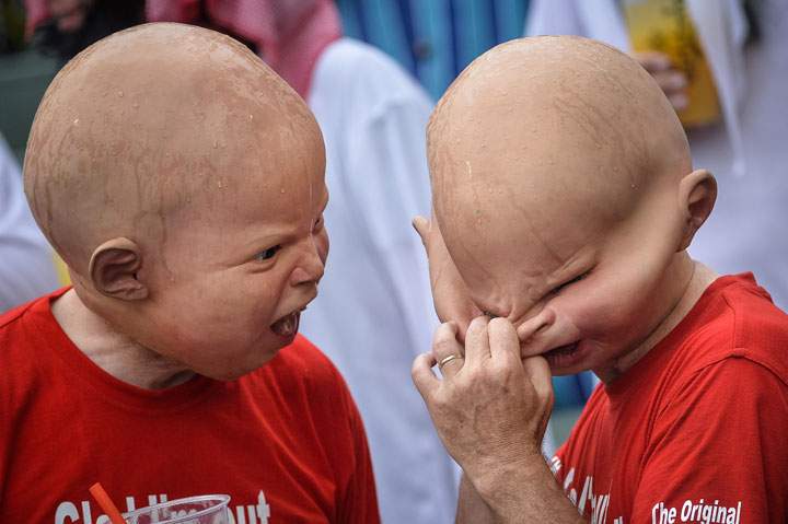 A fan adjusts his latex mask at the rugby sevens tournament in Hong Kong on March 29, 2014.