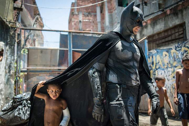 Children play around a man disguised as Batman in Rio de Janeiro, Brazil, on January 9, 2014.