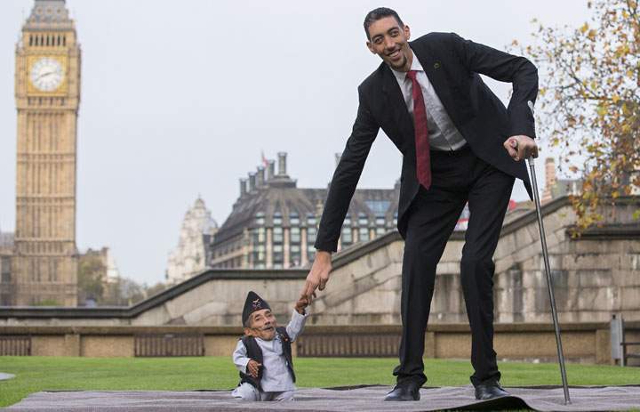 Chandra Bahadur Dangi, from Nepal, the shortest adult to have ever been verified by Guinness World Records, poses for pictures with the world’s tallest man Sultan Kosen from Turkey, during a photocall in London on November 13, 2014.