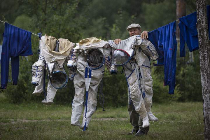 An employee of the Russian Space Training Center hangs out space suits to dry on July 2, 2014.