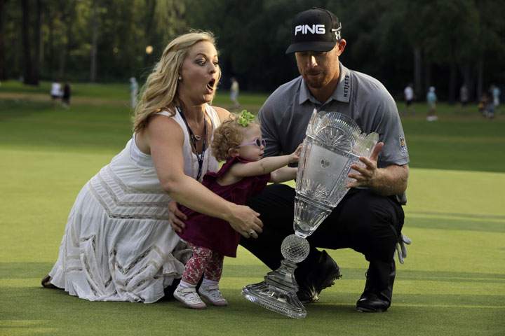 Zoe Mahan, centre, pushes the trophy as her mother Kandi, left, grabs her while they pose with Hunter Mahan, winner of The Barclays golf tournament Sunday, Aug. 24, 2014, in Paramus, N.J.