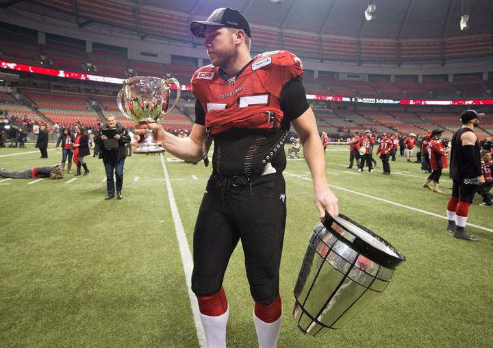 Calgary Stampeders Dan Federkeil holds the Grey Cup trophy after it broke into two pieces after defeating the Hamilton Tiger-Cats to win the CFL championship game in Vancouver, B.C., on Sunday November 30, 2014.