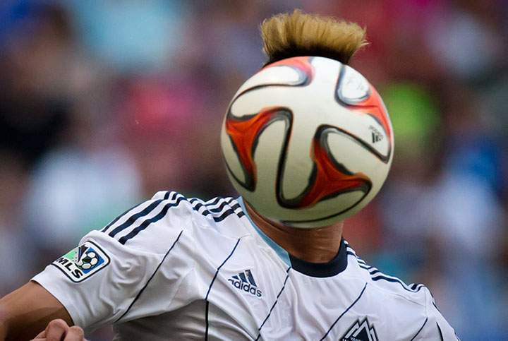 Vancouver Whitecaps’ Erik Hurtado’s face is hidden by the ball during the first half of an MLS soccer game against Sporting Kansas City in Vancouver, B.C., on Sunday August 10, 2014.