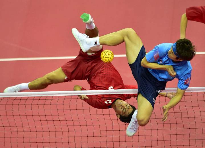 Japan’s Masanori Hayashi (L) strikes the ball against South Korea’s Im An-Soo (R) in the men’s team sepaktakraw preliminary match during the 2014 Asian Games at Bucheon Gymnasium on September 24, 2014.