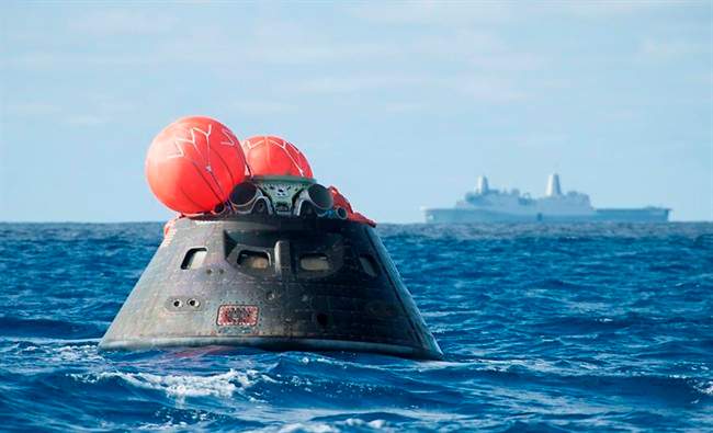This Dec. 5, 2014 image provided by NASA shows NASA\’s Orion spacecraft after splash down as it awaits the U.S. Navy\’s USS Anchorage in the Pacific ocean.