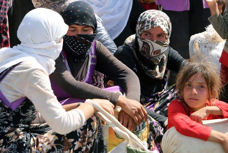 Displaced Iraqi Yazidi women gather at the Bajid Kandala camp near the Tigris River, in Kurdistan's western Dohuk province, where they took refuge after fleeing advances by Islamic State jihadists in Iraq on August 13, 2014.