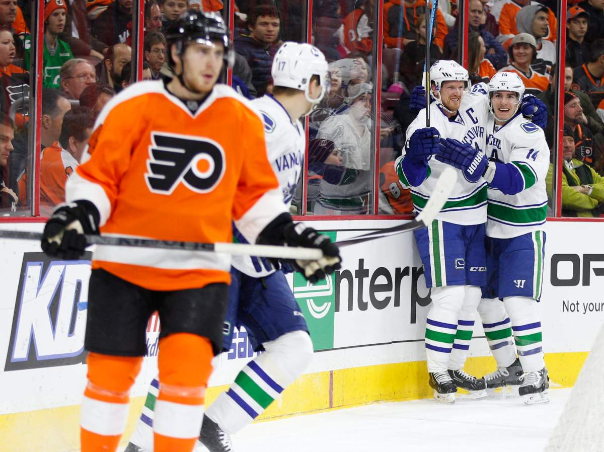 Henrik Sedin celebrates his power play goal with left wing Alex Burrows during the first period. (AP Photo/Chris Szagola).