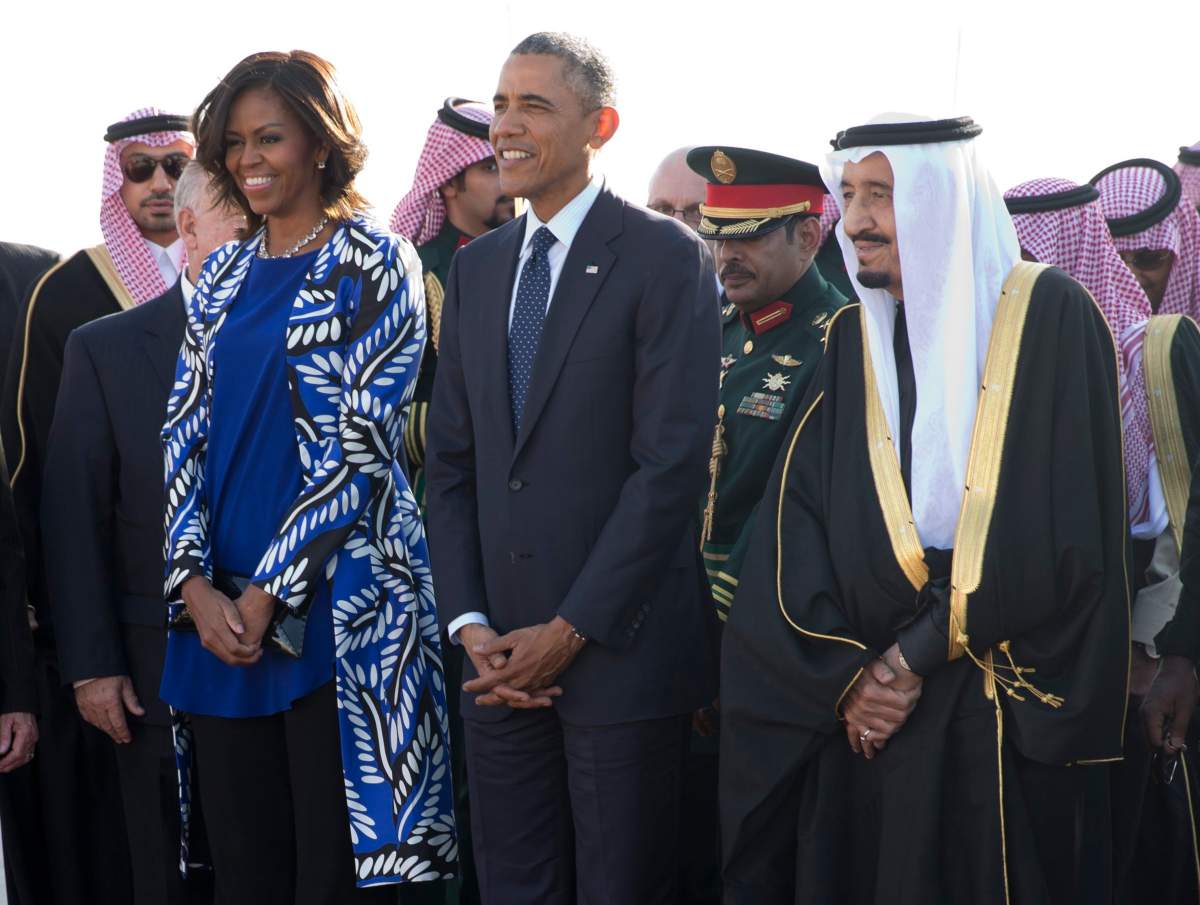 President Barack Obama and first lady Michelle Obama stand with new Saudi King Salman bin Abdul Aziz they arrive on Air Force One at King Khalid International Airport, in Riyadh, Saudi Arabia, Tuesday, Jan. 27, 2015.