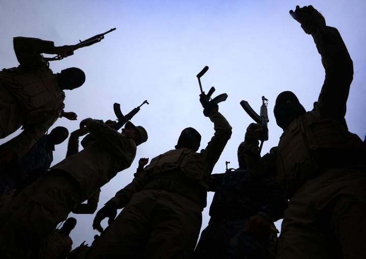Iraqi policemen raise their weapons during a training session at a camp in the Bardarash district, 30 kilometres northeast of Mosul on January 10, 2015 as they prepare to recapture the northern Iraqi city of Mosul, currently under the control of Islamic State group fighters. 