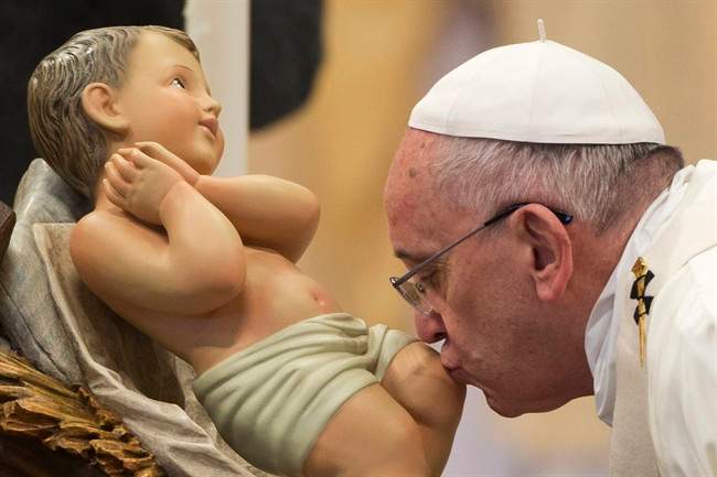 Pope Francis kisses a statue of the baby Jesus on New Year's Day in Vatican City.
