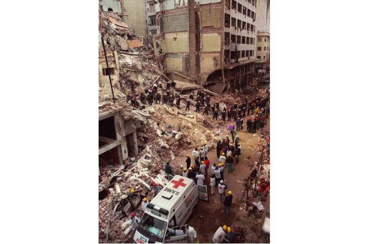 Firefighters and rescue workers search through the rubble of the Buenos Aires Jewish Community on July 18, 1994 photo, after a car bomb struck the building.