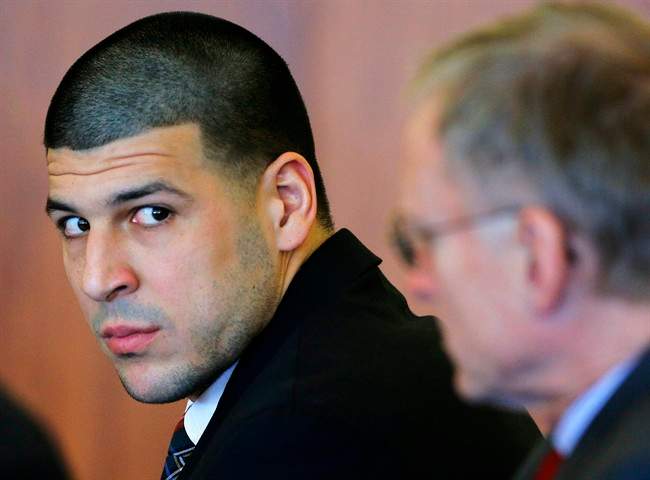 FILE - In this Dec. 22, 2014 file photo, former New England Patriots tight end Aaron Hernandez, left, attends a pretrial hearing in Fall River, Mass. 