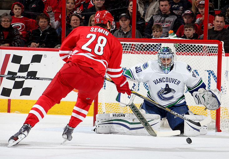 Ryan Miller of the Vancouver Canucks defends the net from Alexander Semin of the Carolina Hurricanes in January. The Canucks have a 92.4 per cent chance of making the playoffs, according to Sports Club Stats.