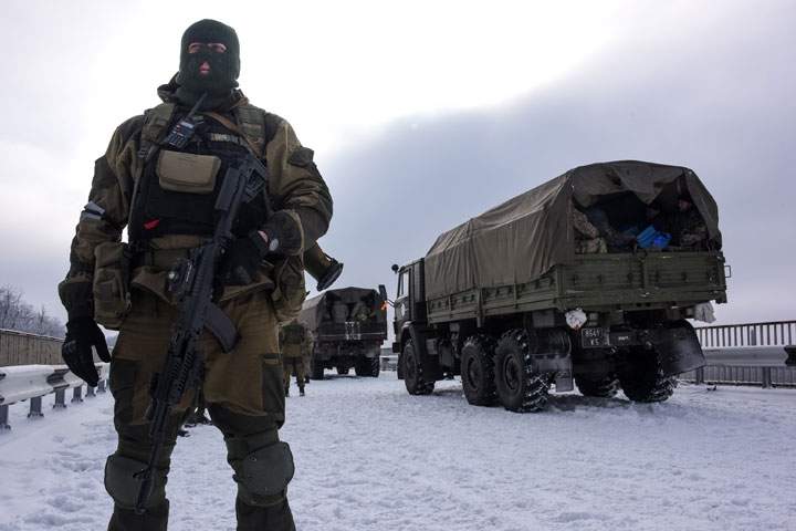A pro-Russian rebel guards the road near the airport of Donetsk,  eastern Ukraine on Tuesday, Jan. 6, 2015. 