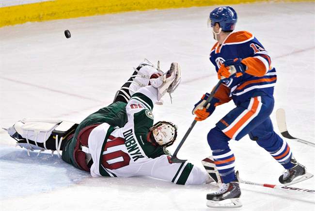 Minnesota Wild goalie Devan Dubnyk (40) makes the same on Edmonton Oilers' Justin Schultz (19) during second period NHL hockey action in Edmonton, Alta., on Tuesday January 27, 2015. THE CANADIAN PRESS/Jason Franson.