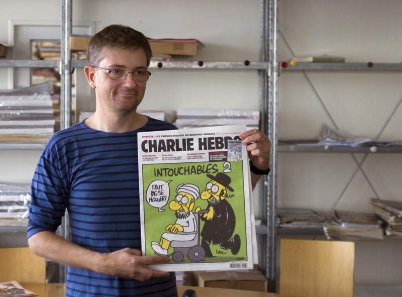 French satirical weekly Charlie Hebdo’s publisher, known only as Charb, presents to journalists, on September 19, 2012 in Paris, at the headquarters, the last issue which features on the front cover a satirical drawing titled ‘Intouchables 2’.