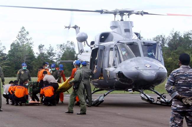 Indonesian military personnel unload the bodies believed to be the victims of AirAsia Flight 8501 from a helicopter at Iskandar Airport in Pangkalan Bun, Central Borneo, Indonesia, Thursday, Jan. 22, 2015. 