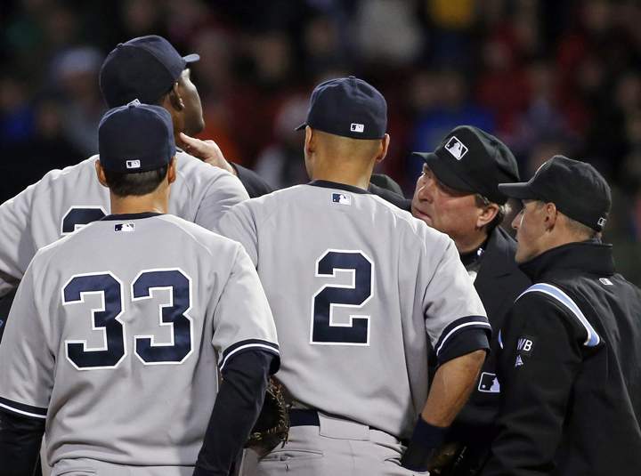 Home plate umpire Gerry Davis touches the neck of New York Yankees starting pitcher Michael Pineda in the second inning of the Yankees’ baseball game against the Boston Red Sox at Fenway Park in Boston, Wednesday, April 23, 2014.