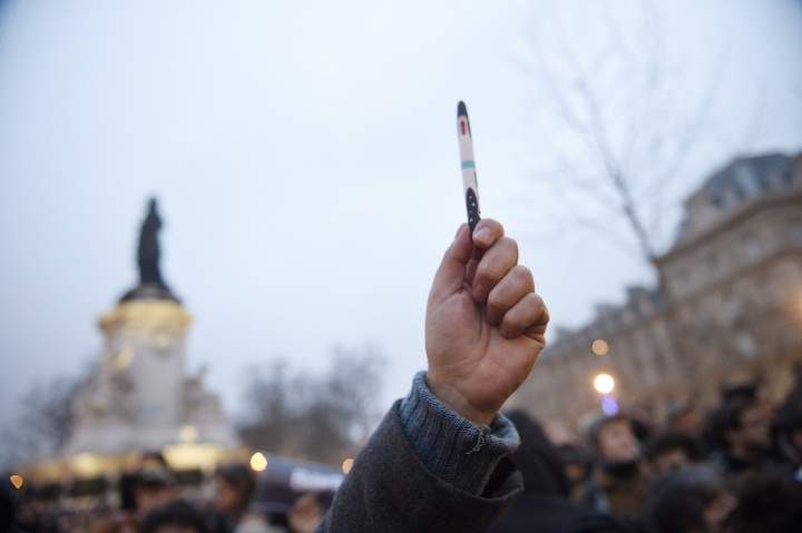 A man raises a pen during a rally in support of the victims of today’s terrorist attack on French satyrical newspaper Charlie Hebdo at the Place de la Republique in Paris, on January 7, 2015.