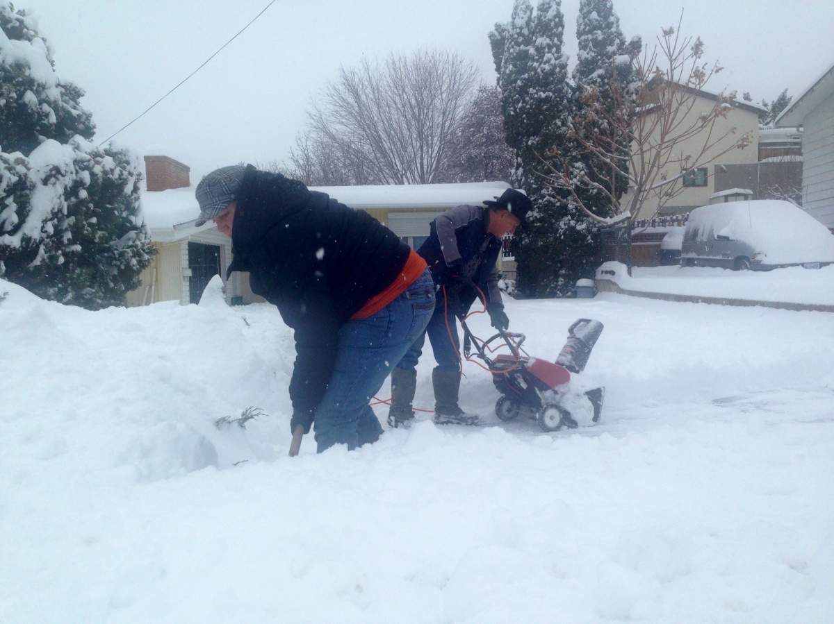 Jenna Daignault and George Payne help their  elderly neighbours clear the sidewalk.