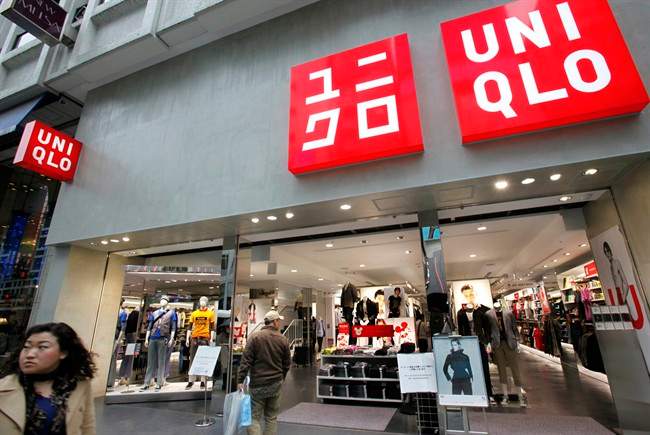 FILE - In this April 7, 2010 photo, a passerby looks at a Uniqlo shop in Tokyo. (AP Photo/Shizuo Kambayashi, File).