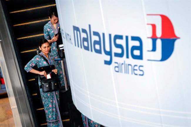 Malaysia Airlines flight crew members head for the the departure lounge at Kuala Lumpur International Airport, in Malaysia, Thursday, Jan. 29, 2015. 