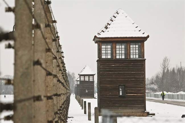 Barbed wire fences and guard towers surround the access road into the Birkenau Nazi death camp in Oswiecim, Poland, Monday, Jan. 26, 2015. 