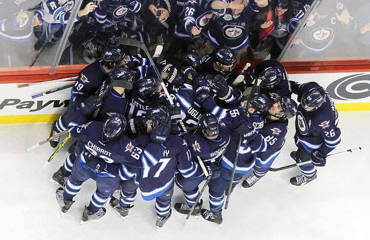 Winnipeg Jets players mob teammate Dustin Byfuglien after he scored the overtime winning goal against the Minnesota Wild in February.