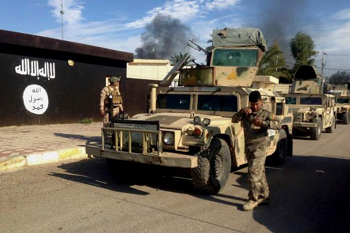 In this Monday, Nov. 24, 2014 file photo, Iraqi army soldiers deploy in front of a court run by the Islamic State group after a military operation to regain control of the town of Sadiyah in Diyala province, 95 kilometers north of Baghdad, Iraq. 