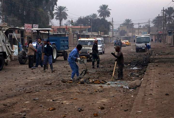 Municipality workers clean up debris in the aftermath of a car bomb explosion in Baghdad's southeastern suburb of Jisr Diyala, Iraq, Wednesday, Feb. 25, 2015. 