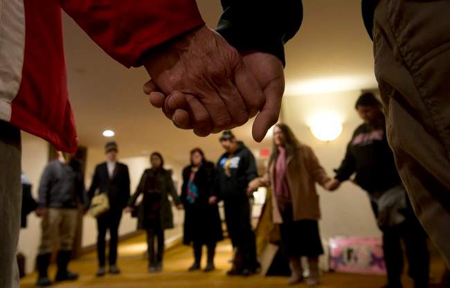 A group of aboriginal protesters hold hands during a prayer outside the National Roundtable on Missing and Murdered Indigenous Women and Girls Friday, February 27, 2015 in Ottawa.