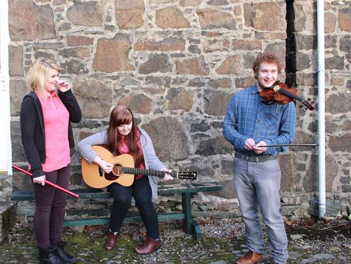 Caitlin McNeill, seated with guitar, posted the photo that has gone viral.