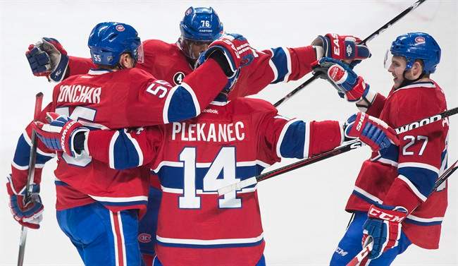 Montreal Canadiens' Tomas Plekanec (14) celebrates with teammates, Saturday, Feb. 7, 2015.