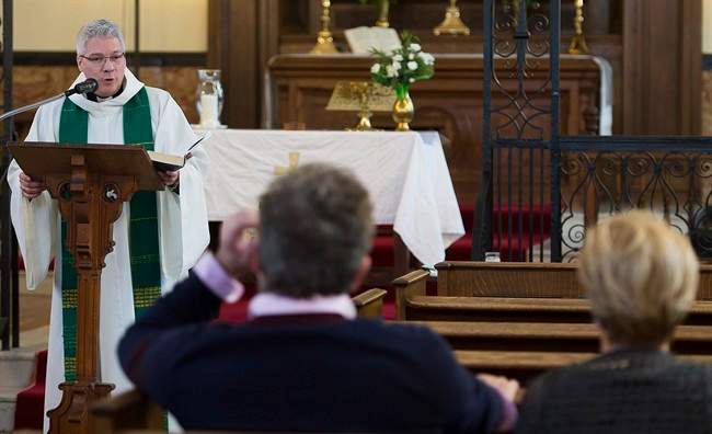 Reverend Yves Samson speaks to the faithful during mass at St. James Anglican Church in Trois-Rivières, Que.