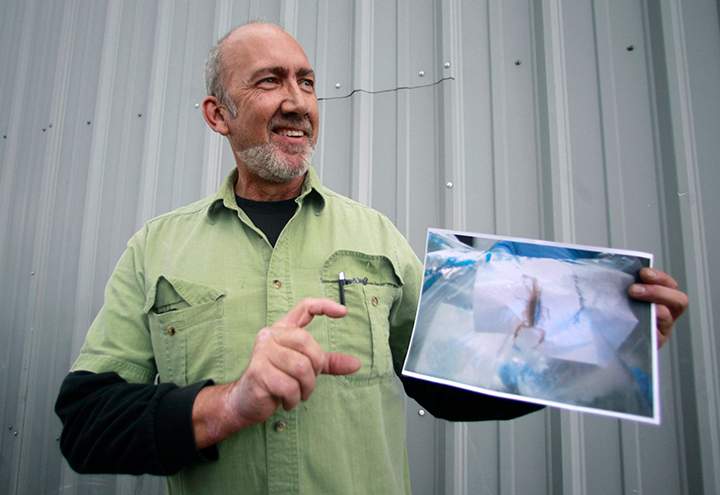 Jeff Ellis holds a photograph of the scorpion which stung him while he was trying to sleep on a red-eye Alaska Airlines flight on June 17, 2011.