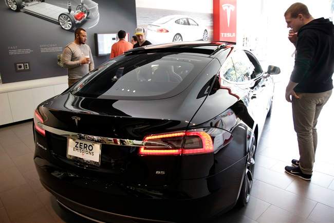 People check out the Tesla model S at the Tesla showroom at the the Third Street Promenade in Santa Monica, Calif. 