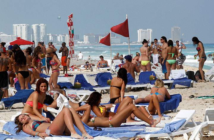 In this March 10, 2012 file photo, people hang out on the beach during spring break in Cancun, Mexico. The beach resort remains a top destination for American spring-breakers seeking an escape from winter.
