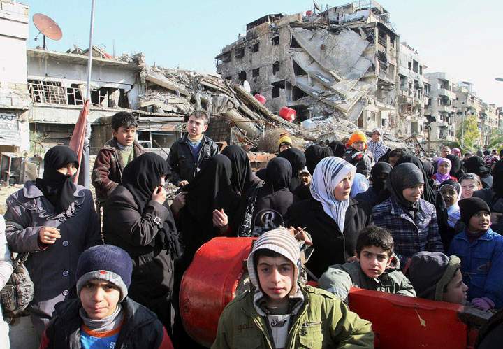 Hundreds of Syrians  wait in line at a military checkpoint in the town of Beit Sahm, south of the capital, Damascus, Syria on Jan. 14, 2015.