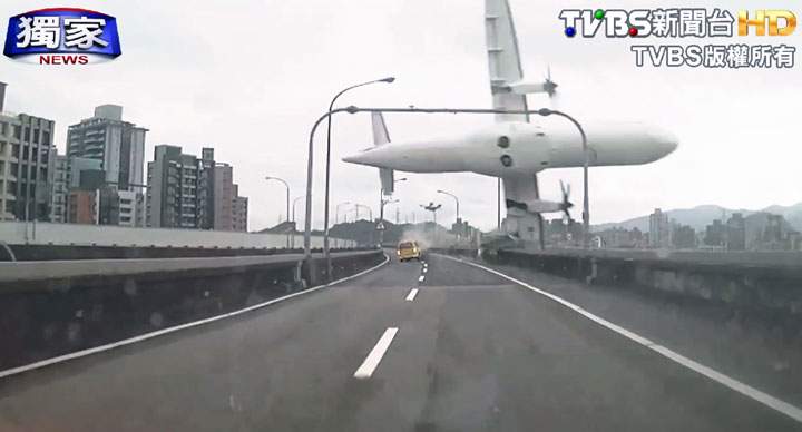 This image taken from video provided by TVBS shows a commercial airplane clipping an elevated roadway just before it careened into a river in Taipei, Taiwan.