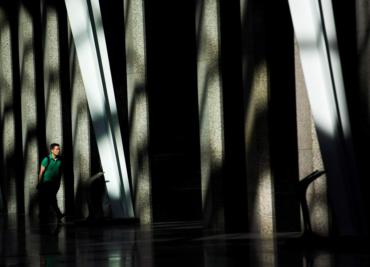 A man makes his way to work though the early morning light at Brookfield Place in downtown Toronto on Wednesday, August 13, 2014.