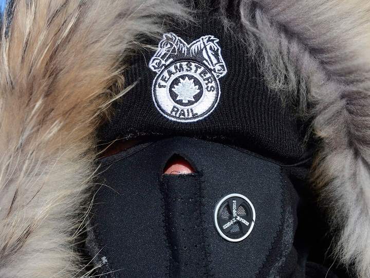 A bundled up Canadian Pacific Railway worker walks the picket line while on strike at the Cote Saint-Luc railyard in Montreal on Monday, Feb. 16, 2015.