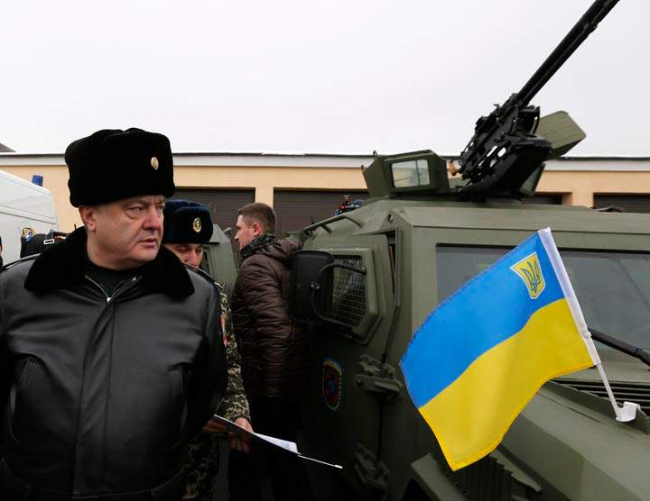 Ukrainian President Petro Poroshenko, left, inspects military armoured personnel carriers during his visit to the State Border Guard Service in Kiev, Ukraine, Saturday, Feb. 14, 2015.