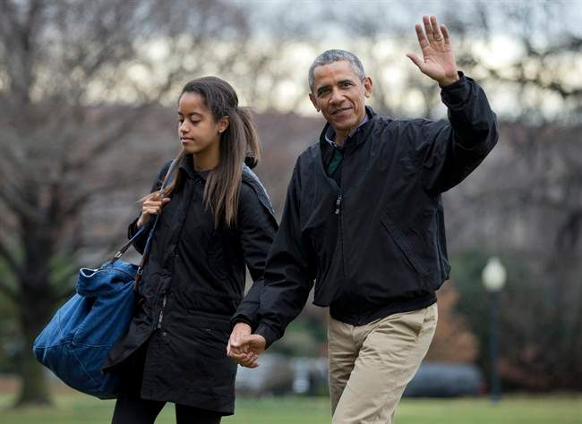FILE – In this Jan. 4, 2015 file photo, President Barack Obama, with his daughter Malia Obama, waves as they arrive at the White House in Washington.