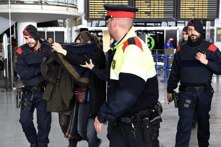 Police escort a family member of an aircrash victim at Barcelona's El Prat airport on March 24, 2015 after a Germanwings airliner crashed near a ski resort in the French Alps with all 148 people on board feared dead,