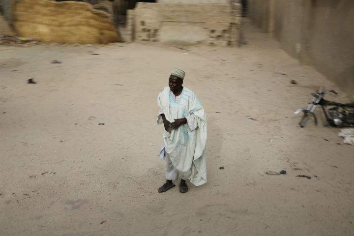 An elderly Nigerian man, one of the very few who remained in the Nigerian city of Damasak, Nigeria, looks at a convoy of Chadian soldiers escorting a group of journalists, Wednesday March 18, 2015.