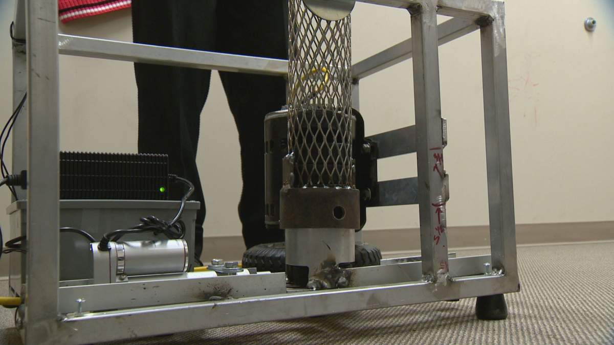 This device, designed by a team of three, shoots out hockey pucks using a rotating tire.